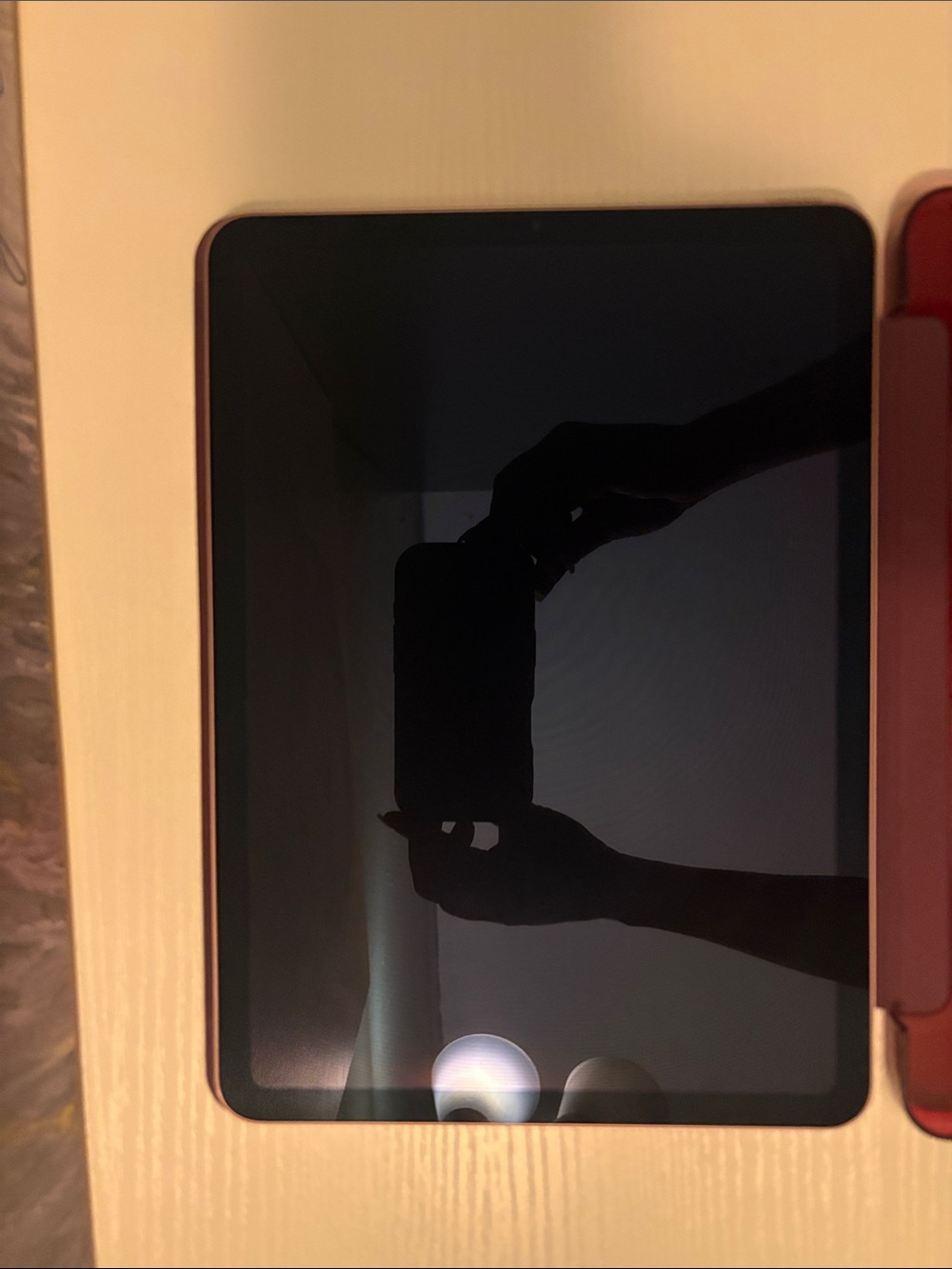 Apple Tablet with Black Screen and Red Case Accent